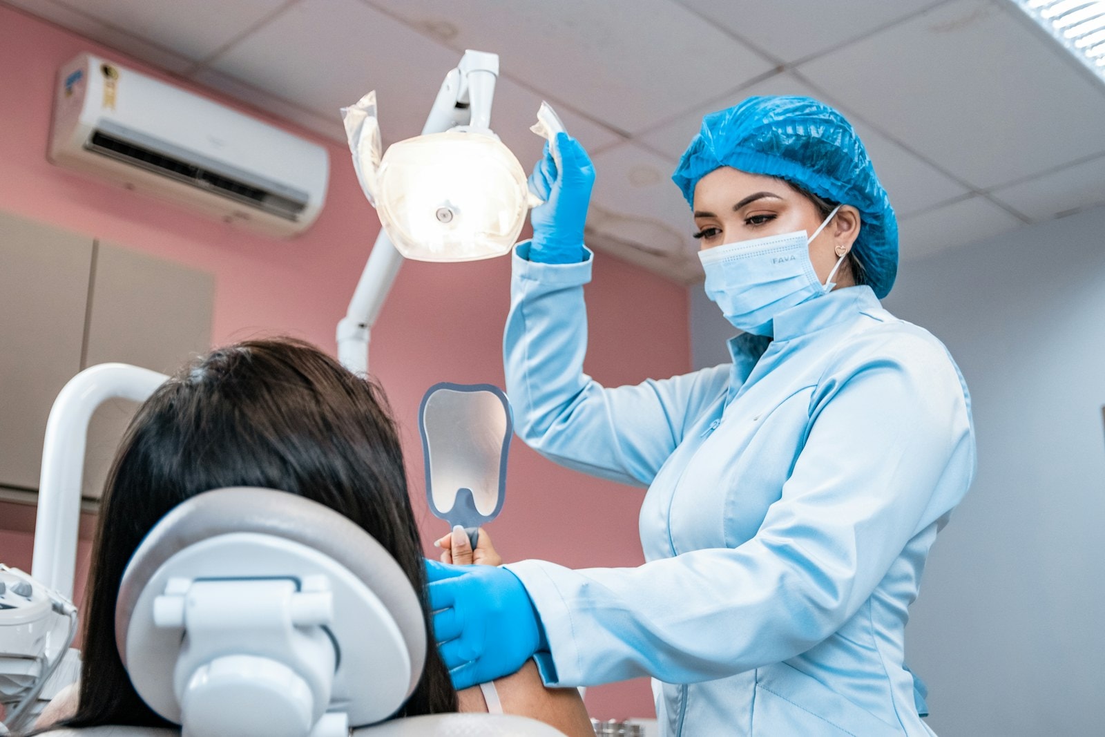 Medic stomatolog tratând o pacientă în scaunul dentar